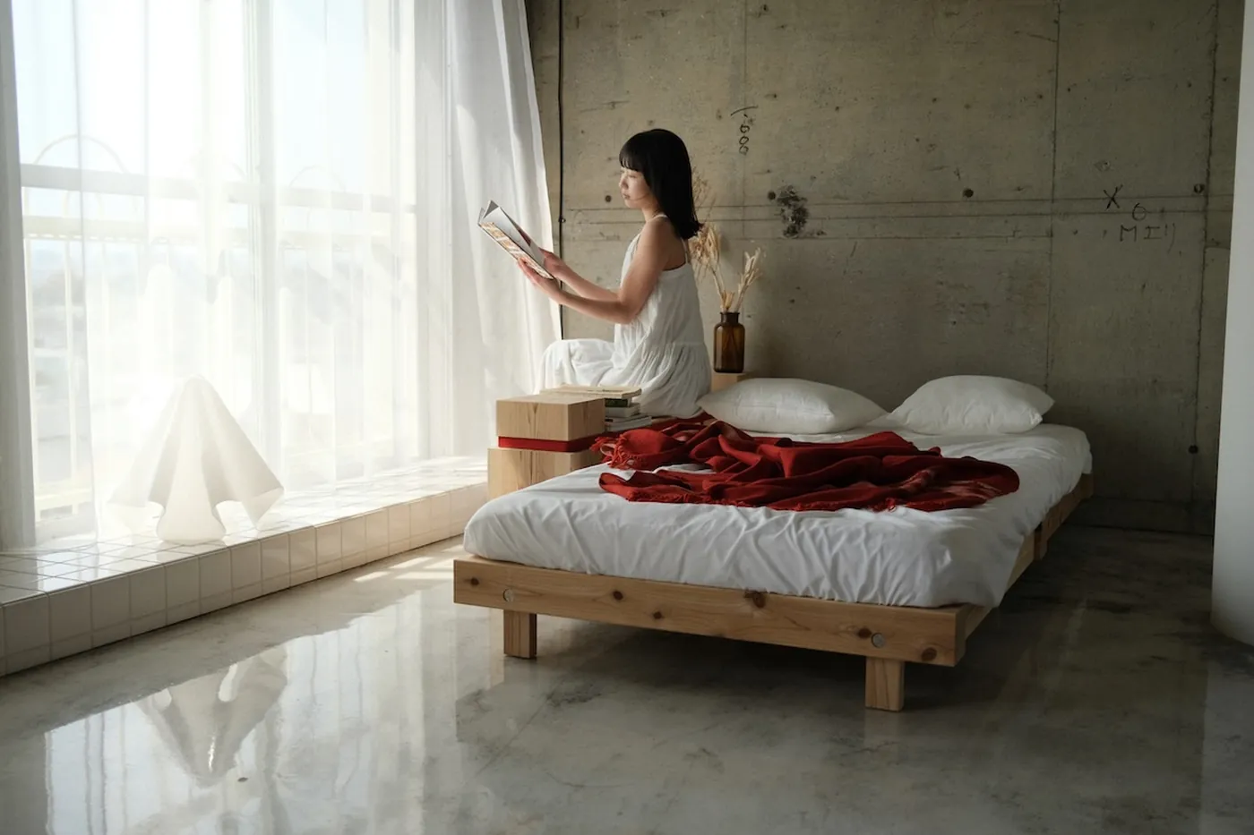 窓辺の RAFT に腰かけて本を読む様子